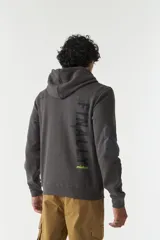 Campera de felpa color beige con capucha y cordón ajustable, cierre frontal, bolsillos con cierre, lettering estampado en la espalda y logo en grifa de goma.