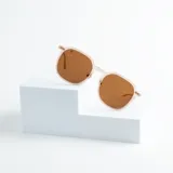 Lentes de sol con montura geométrica color rosa pálido y lentes marrones con protección UV400.