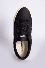 Zapatillas bajas color beige claro, con cordones y suela blanca.