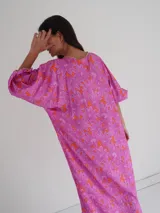 Vestido midi de corte holgado con estampado floral en tonos rosa y naranja, escote en V y mangas cortas amplias.