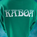 Buzo verde con estampa rectangular en el pecho con dibujo de la muerte y el logo de la marca.