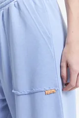 Pantalón de felpa celeste con cintura elastizada ajustable y bolsillos laterales.