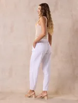 Pantalón largo de lino y rayón a rayas verticales grises y blancas. Tiene pretina elastizada con lazo de ajuste, bolsillos delanteros y traseros.