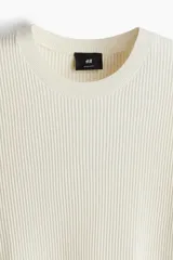 Remera color crema de punto acanalado suave de mezcla de algodón y viscosa. Tiene cuello redondo y mangas cortas con ribete acanalado fino en cuello, puños y bajo.