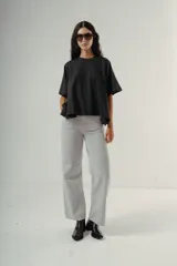 Camiseta negra de algodón con corte amplio y mangas cortas. Presenta un pequeño bordado sutil en el pecho.