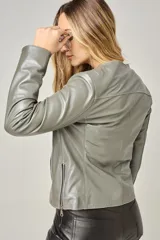 Campera de cuero color natural, con cuello redondo, cierre frontal con cremallera y bolsillos laterales con cierre. Diseño clásico y corte entallado.