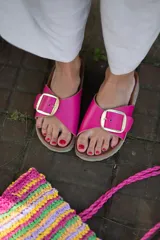 Sandalias de cuero color marrón con hebilla metálica plateada.