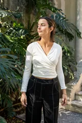 Top blanco de manga larga con escote en V cruzado y corte ajustado.