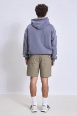 Buzo canguro con capucha color lila, de friza gastada.