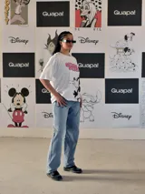 Remera blanca de corte oversize con estampado frontal de Mickey Mouse en movimiento y texto "Mickey Mouse" en rosa.