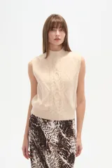 Chaleco sin mangas color beige, con cuello alto y tejido de ochos.