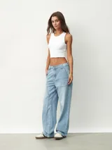 Pantalón de jean celeste, de corte ancho y tiro alto, con bolsillos laterales y traseros.