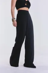 Pantalón negro de corte palazzo con cintura alta y elástica.