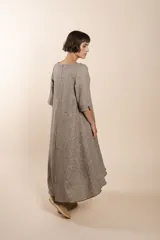 Vestido largo debajo de la rodilla, acampanado, color marrón, con cuello bote, bolsillos en el corte y mangas 3/4.