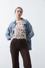 Pantalón negro de tiro alto, corte recto y silueta clásica. Presenta costuras verticales marcadas en la parte delantera de las piernas.