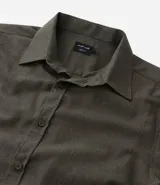 Camisa de manga larga color blanco, confeccionada en tricolina de algodón con efecto melange. Tiene cuello inglés, abotonado delantero y puños con botones.