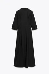 Vestido midi negro tipo gabardina, con cuello solapa, manga tres cuartos con puño y trabillas en el hombro, bolsillos laterales ocultos, pinzas y cierre frontal con botones.