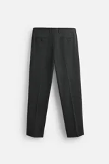 Pantalón de vestir azul marino, de corte slim fit, con bolsillos laterales y traseros. Se ajusta a la cintura con cinturón de cuero marrón.