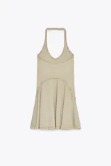 Vestido corto color beige con cuello halter y falda con godets.
