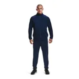 Conjunto deportivo Under Armour gris con detalles en negro. Incluye campera con cierre y pantalón con cintura elástica y cordón ajustable. Ambos con logo de la marca en el pecho y en la pierna.