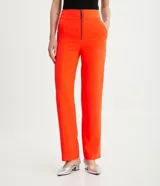 Conjunto sastrero color naranja, compuesto por un blazer entallado con solapas de muesca, cierre con lazo y pantalón de vestir recto de tiro alto.