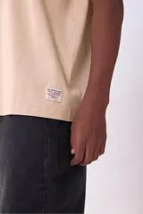 Remera color beige de corte recto y mangas cortas.