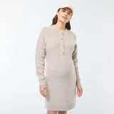 Vestido corto color beige, tipo sweater, de tejido de punto con cuello redondo y manga larga. Presenta una abertura frontal con botones para facilitar la lactancia.