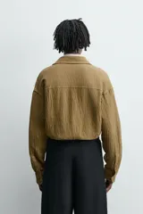 Sobrecamisa color caqui de algodón y lino con efecto arrugado, corte relaxed fit, cuello solapa, manga larga con puños abotonados y cierre frontal con botones.