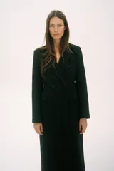 Abrigo largo de Zara Woman Collection confeccionado en tejido con 30% lana. Tiene cuello solapa de muescas, manga larga con abertura y botones, bolsillos con solapa en el delantero y de vivo en el pecho. Forro interior a tono y cierre frontal cruzado con botones.