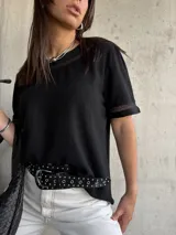 Remera negra de mangas cortas con detalle de encaje en cuello y mangas.