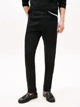 Jean negro Tommy Hilfiger modelo Harlem de corte recto, con cierre de cremallera y botón, diseño de cinco bolsillos, detalles distintivos de la marca y logo bordado en el bolsillo trasero.