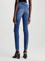 Jeans skinny de tiro alto color azul medio, con lavado gastado y roturas en las rodillas.