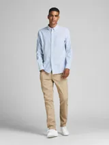 Camisa de vestir a rayas verticales celestes y blancas, de manga larga y cuello abotonado. Cierre con botones y corte slim fit.