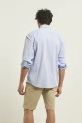 Camisa celeste de manga larga con cuello abotonado, corte clásico y bolsillo en el pecho.
