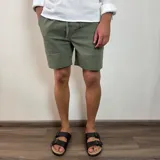 Bermuda color verde militar, de corte recto y largo a la rodilla, con cintura ajustable con cordón y bolsillos laterales. Confeccionada en simil lino.