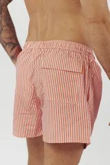 Short de baño con estampado de hojas de palmera en tonos beige, verde y naranja.