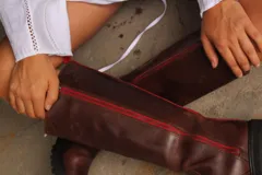 Bota de caña alta hasta la rodilla, color marrón, 100% de cuero, con suela track. Presenta cierre lateral con cremallera azul.