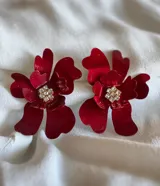 Par de aros con forma de flor color lila con centro de strass plateado.