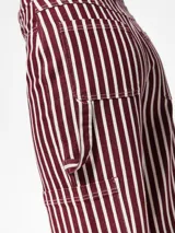 Pantalón de denim de algodón a rayas verticales color borgoña y blanco, con bolsillos cargo, delanteros y traseros, y pasadores para cinturón.