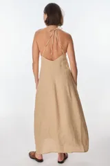 Conjunto de top halter con abertura en el abdomen y falda cruzada con ruedo desflecado, color fucsia.