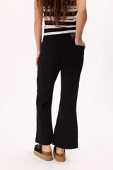 Pantalón jean negro de tiro medio con pierna ancha acampanada y corte cropped.