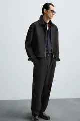 Pantalón negro de corte recto, con cintura elástica, bolsillos laterales y trasero.