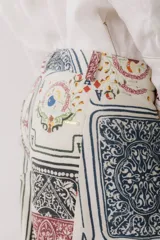Pantalón jean wide leg color blanco con estampado de cartas de baraja.