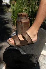 Sandalias con base de corcho y dos tiras anchas de cuero azul con hebillas ajustables.