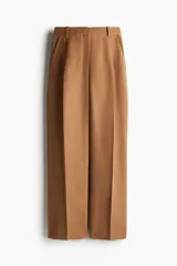 Pantalón de vestir color camel, de corte amplio, tiro alto y largo hasta el tobillo.