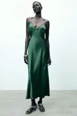 Vestido midi verde esmeralda de satén, con escote en pico, tirantes finos regulables con apliques dorados y cierre lateral con cremallera oculta.