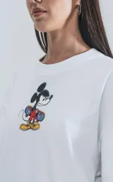 Remera blanca de algodón premium con cuello redondo y calce oversize. Presenta un estampado central de Mickey Mouse con patineta.
