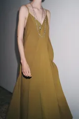 Vestido midi color ocre de Zara Woman Collection, confeccionado en hilatura con mezcla de algodón. Presenta escote pico, tirantes finos y tejido con volumen.