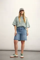 Remera color verde agua, de corte holgado y mangas cortas con dobladillo.