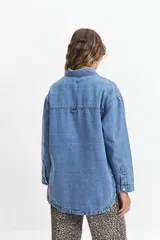 Campera de jean celeste de corte holgado, con cuello camisero, cierre frontal con botones metálicos, mangas largas con puños abotonados, bolsillos frontales con solapa y costuras a la vista.